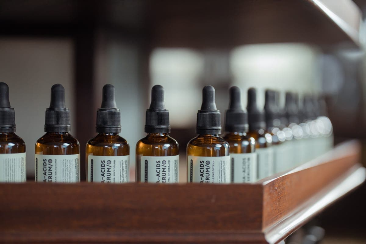 An assortment of detailing bottles and a polisher arranged on a bright bench