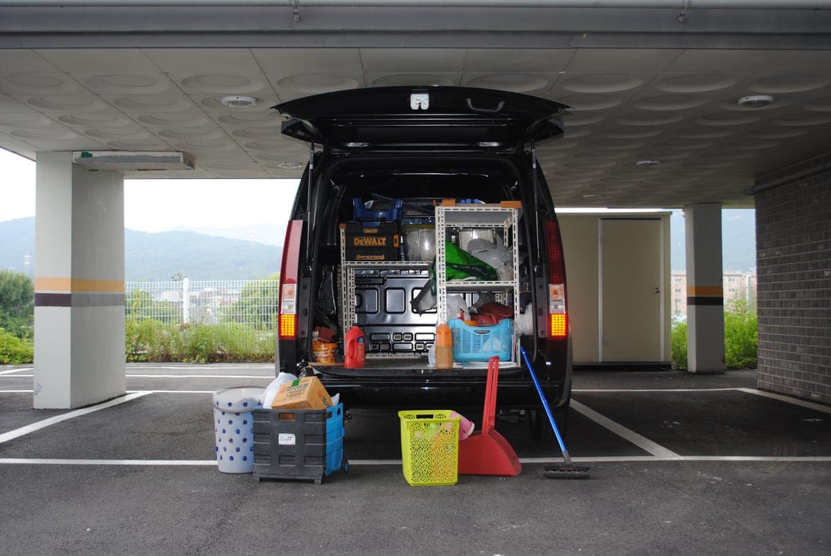 Cleaning supplies and tools loaded in the back of a van
