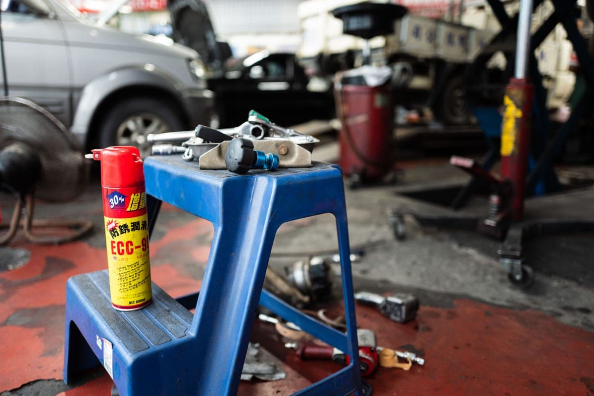 A low rolling stool beside a car wheel in a garage