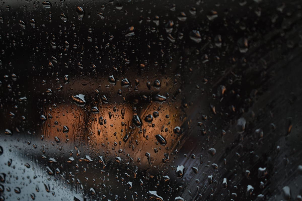 Rain beading and running off a car windshield seen from inside the vehicle