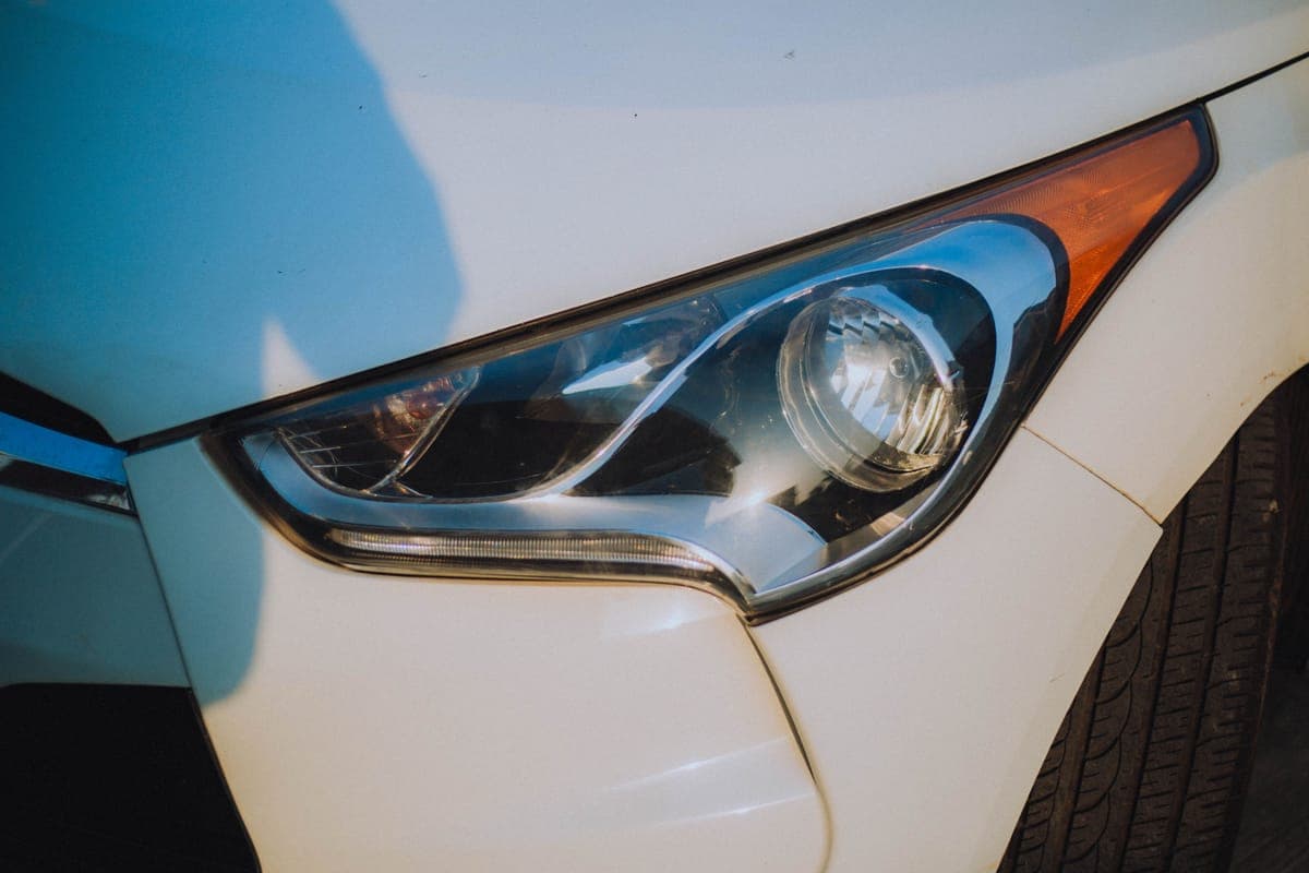 A clear restored headlight beside a yellowed one on a light-colored car
