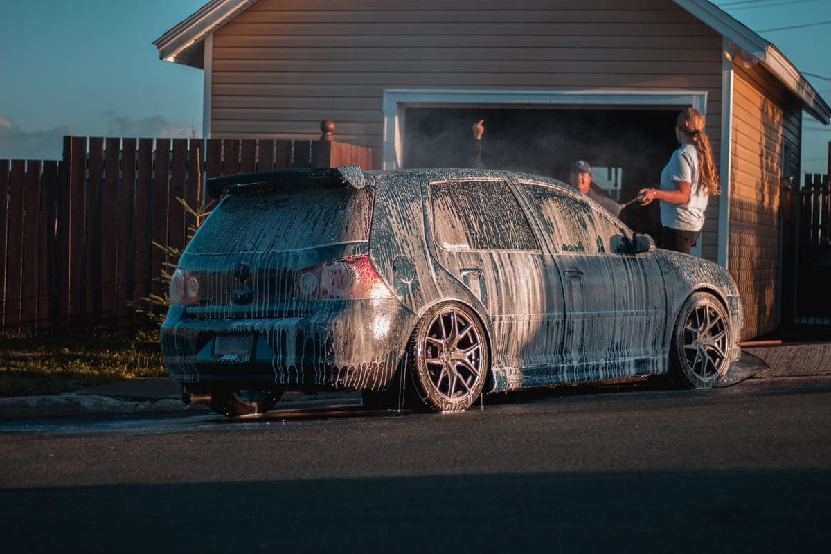 A complete detailing setup arranged on a driveway beside a clean car