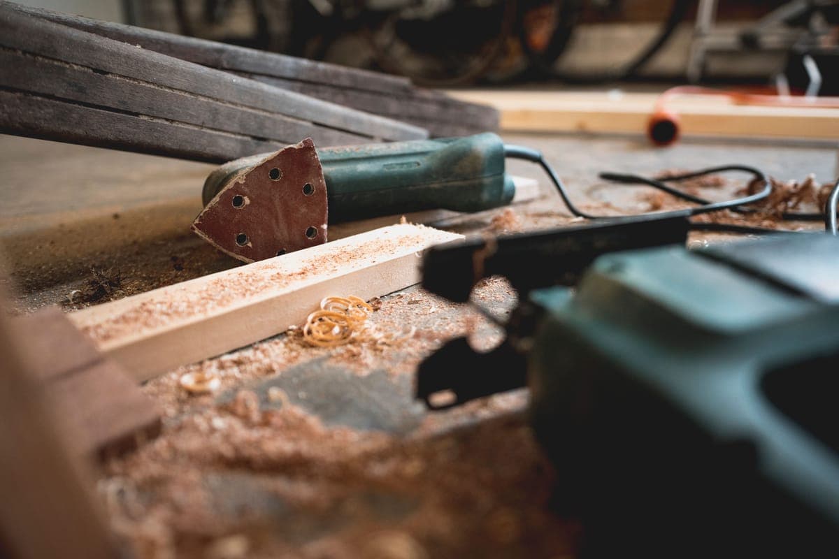 A cordless polisher and a corded machine side by side on a bench