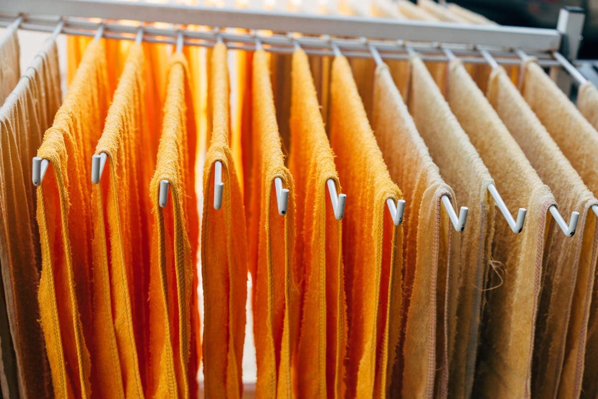 Clean towels and polishing pads drying on a rack in a bright garage