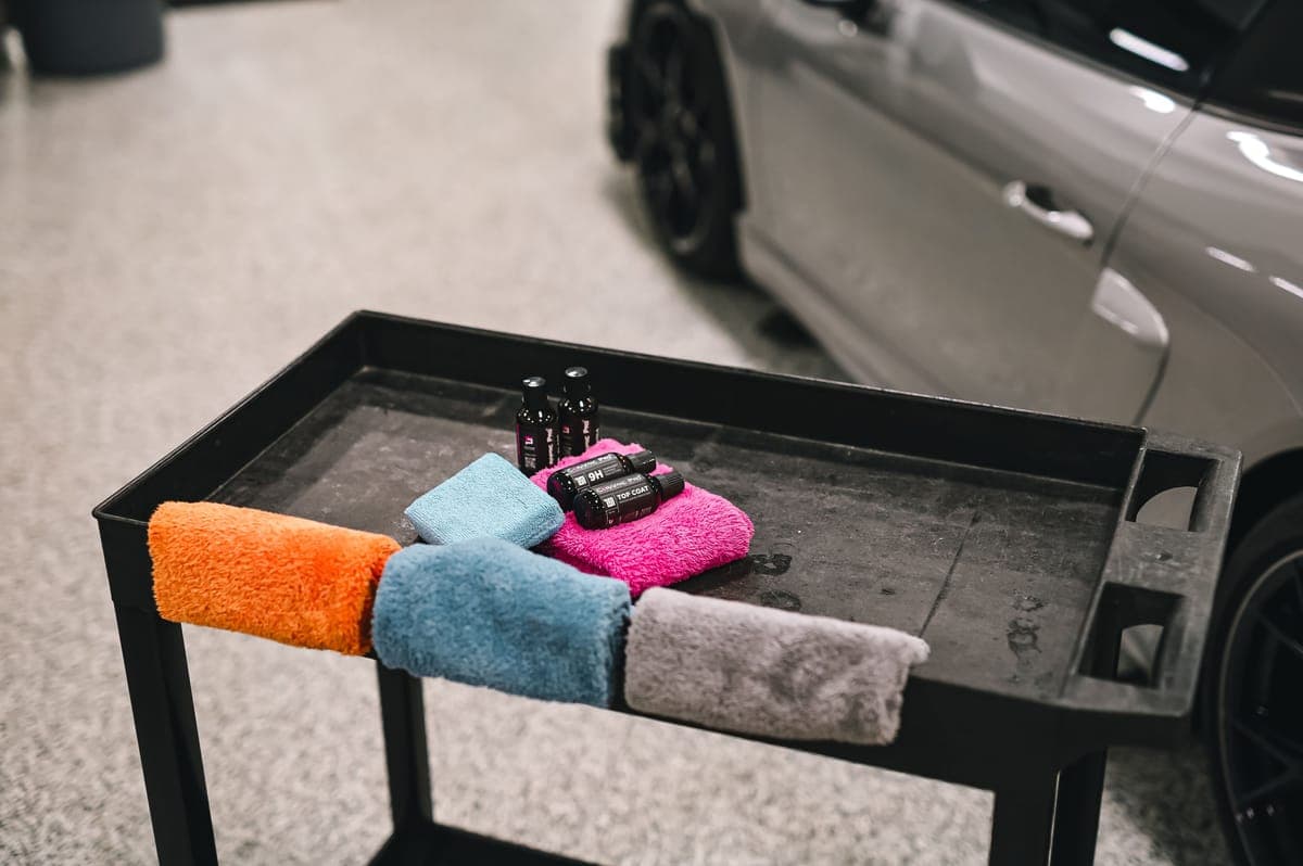 Folded microfiber towels stacked on a detailing cart