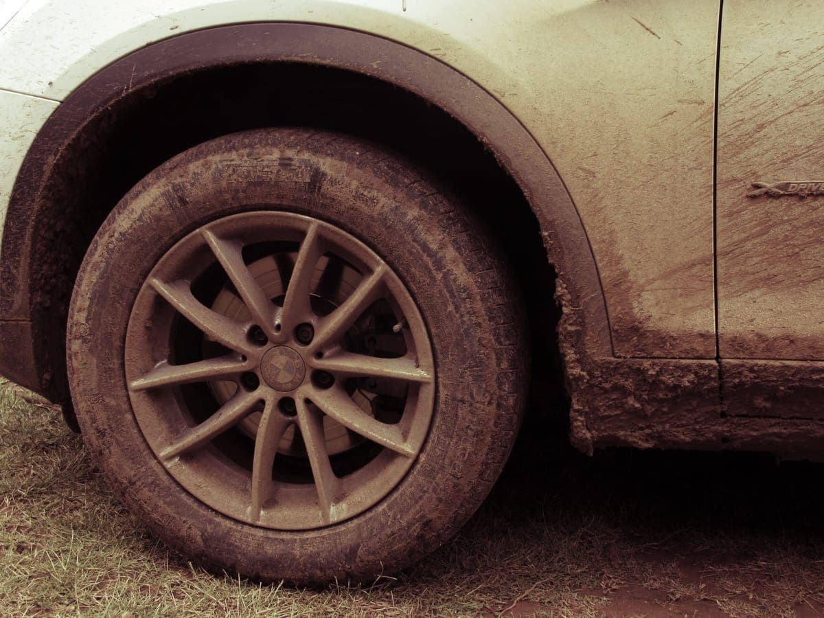 A wheel arch and tire caked in road grime