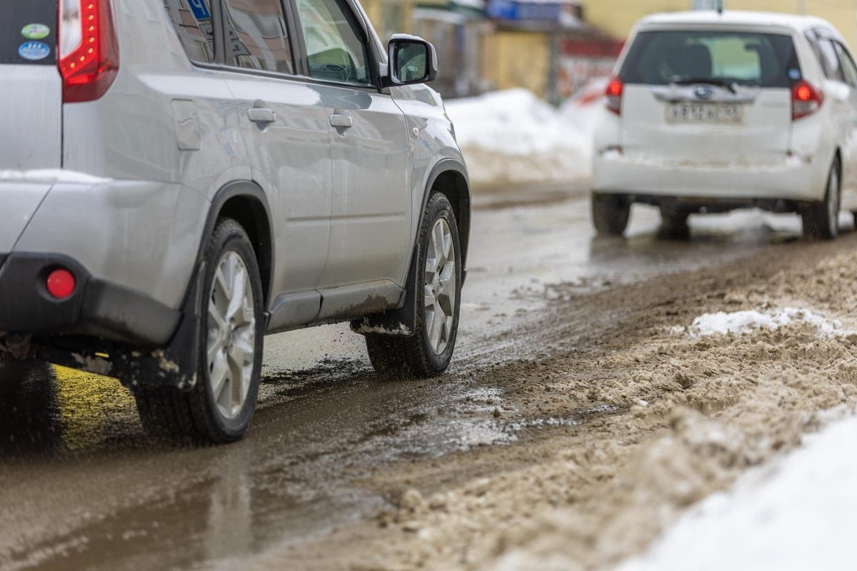 Cars driving on a slushy, snow-covered road