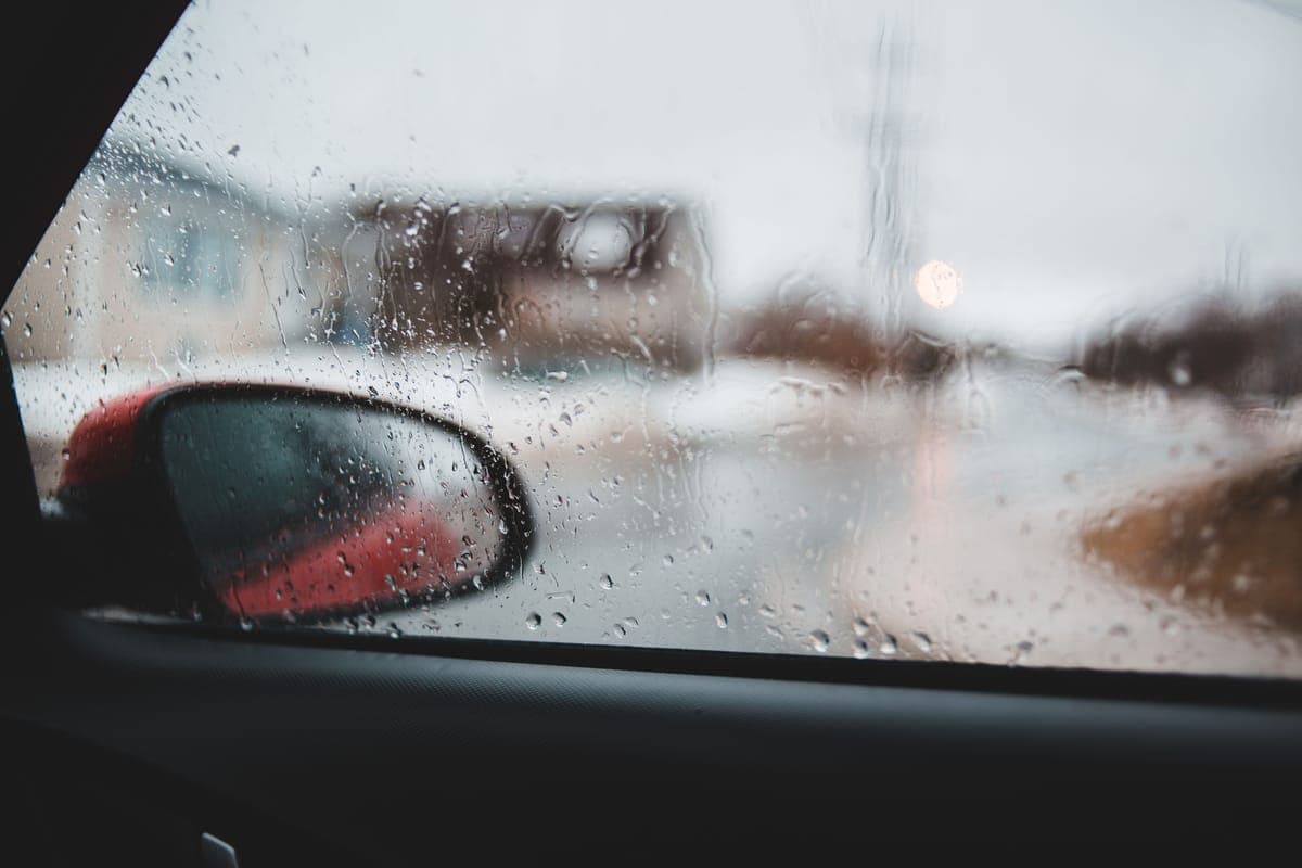 Rain running down a car side window, seen from inside