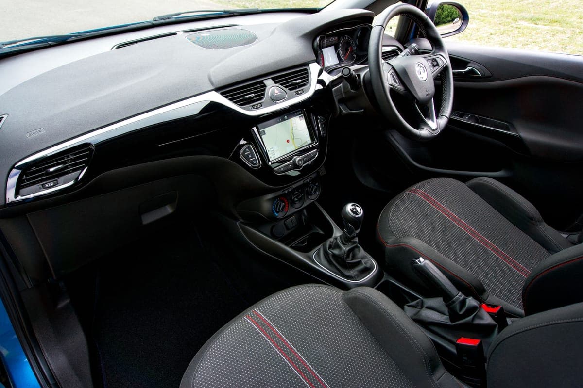 A car interior with the dashboard and footwell carpet in view