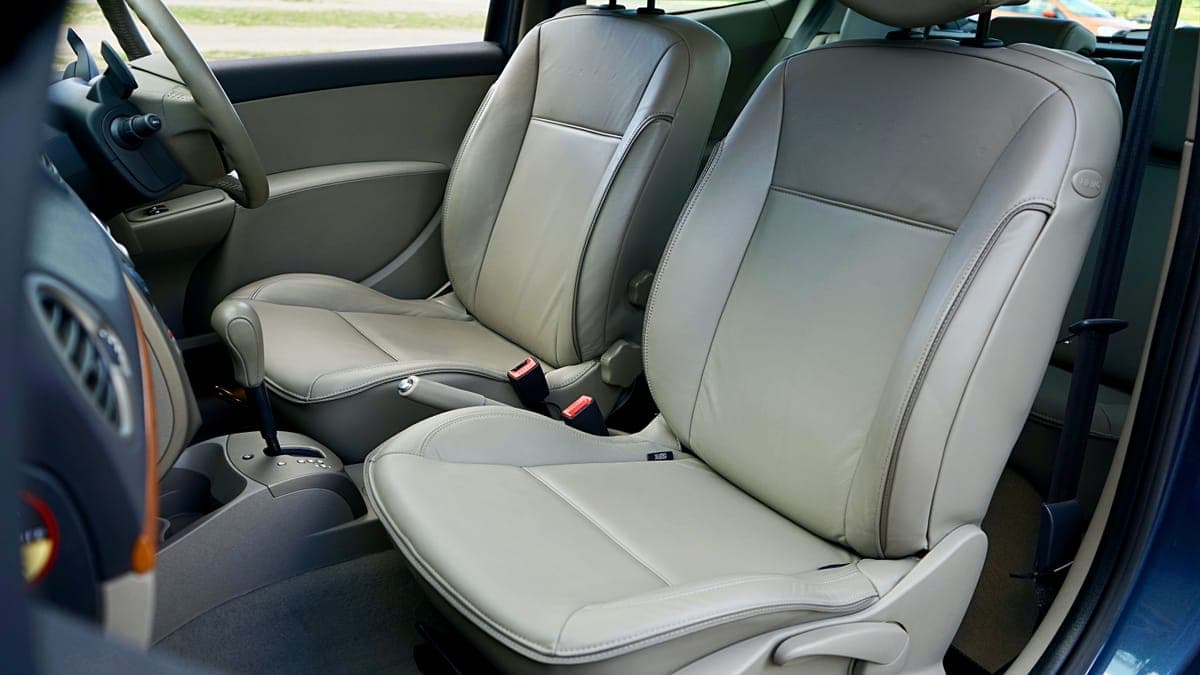 Beige leather front seats seen through an open car door