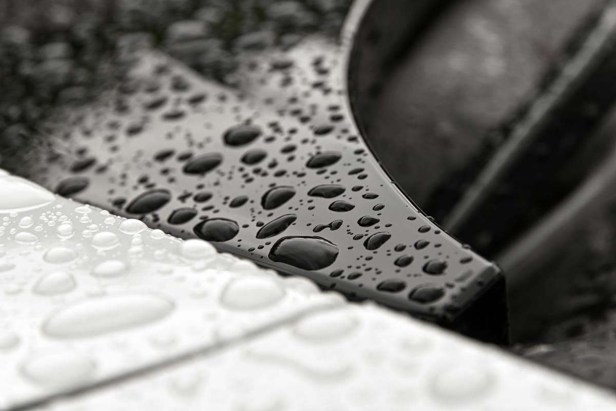 Water beaded on black trim and the white paint beside it