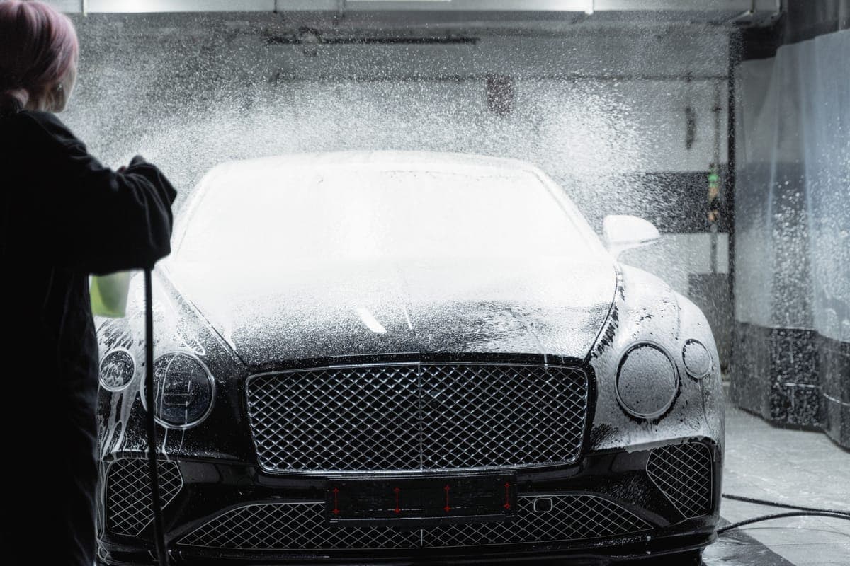 Thick white foam covering a car in a driveway