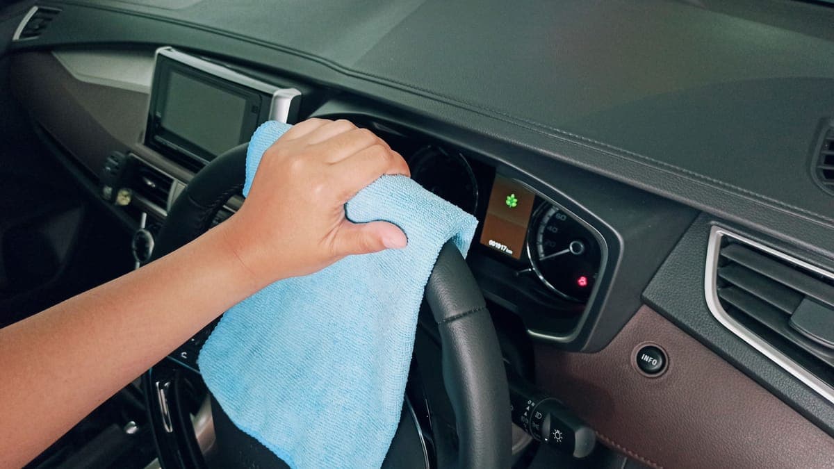 A cloth and brush beside a clean leather car seat in soft light
